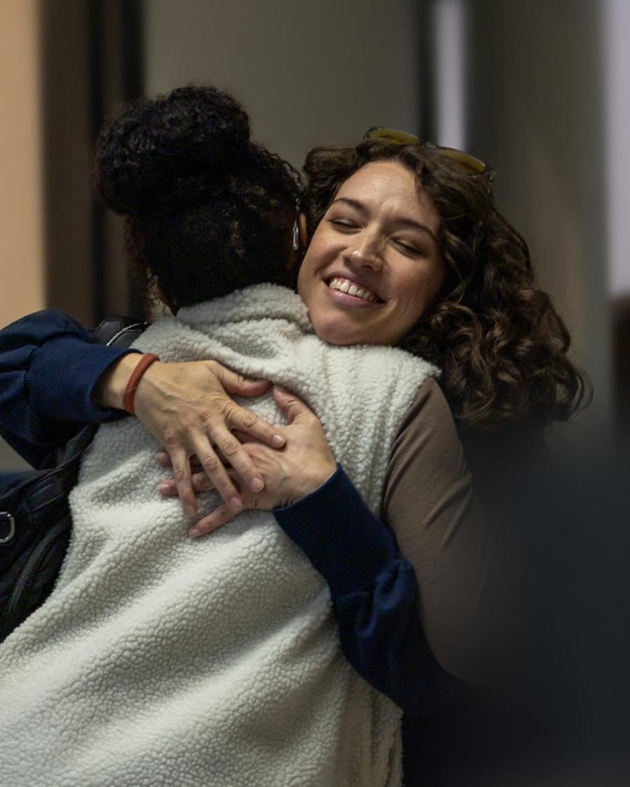 Two friends hugging hello at check-in